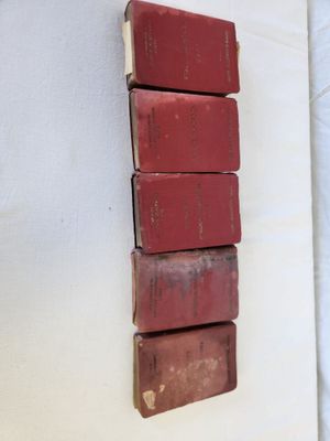 several red books stacked on top of each other on a wall