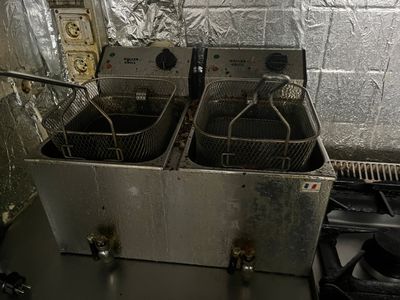 deux friteuses posées sur un plan de travail dans une cuisine