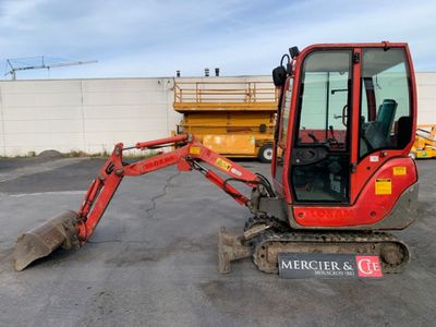 a small red excavator that is parked in a parking lot