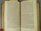 someone is holding a book open on a gray surface