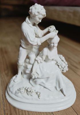 une figurine représentant un homme en train de couper les cheveux d'une femme