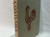the book is sitting on a white surface with a red rooster on it