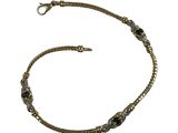 une image représentant un bracelet en or orné de pierres noires sur fond blanc