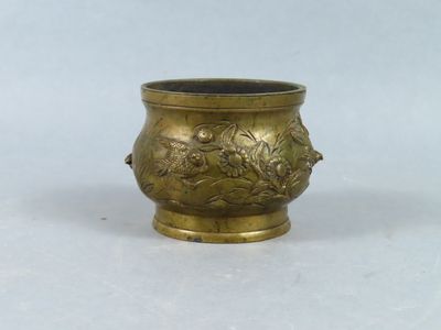 an image of a small brass vase with flowers and leaves on it