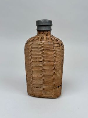 une image représentant une petite bouteille en osier avec un bouchon noir