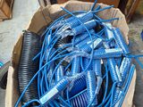 a cardboard box full of blue hoses on the floor