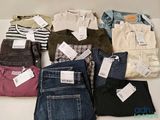 de nombreux jeans posés sur une table, avec leurs étiquettes de prix