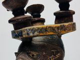 a wooden sculpture of a head with three bowls on top of it