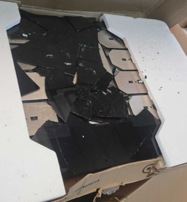 une boîte en carton sur laquelle repose un morceau de verre cassé
