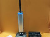 a vacuum that is sitting on a chair next to a laptop