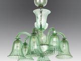 a green glass chandelier with five lights hanging from the ceiling