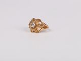 gros plan d'une bague en or sur une surface blanche