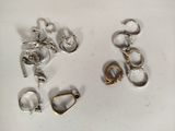 several pairs of silver and gold earrings on a white surface
