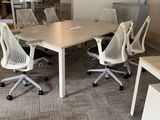 tables and chairs in an office setting with a large window