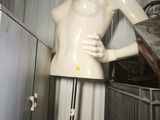a mannequin sitting on a stand in the corner of a room