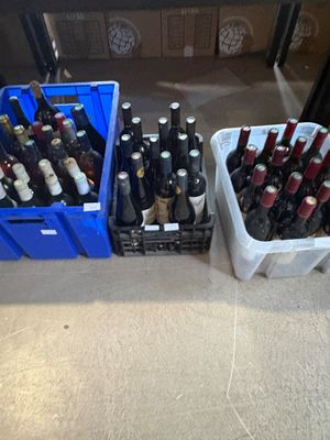 many bottles of wine in plastic containers on the floor