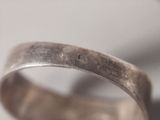 a close up of a silver ring with a diamond on it