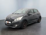 La petite voiture grise est garée dans une pièce au sol noir.
