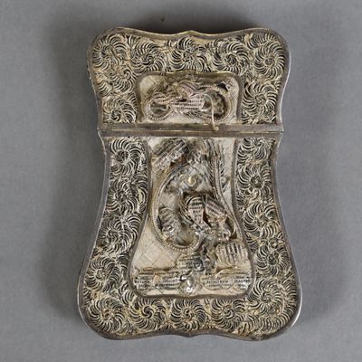 an antique silver cigarette case with a dragon on it