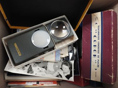 une boîte remplie de livres et une paire de lunettes loupes