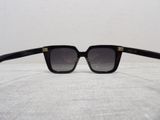 the sunglasses are black and have gold details on the temples