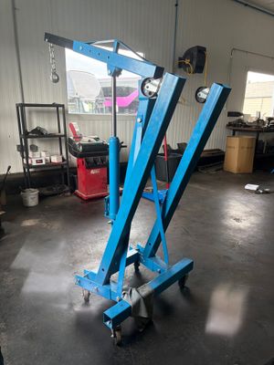 a close up of a blue scissor in a garage