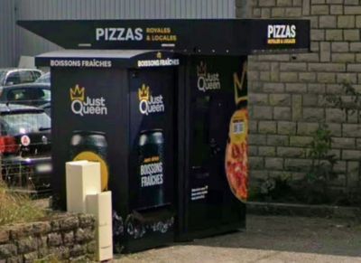 une boîte noire décorée de pizzas, posée devant un immeuble