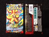 two packs of pokemon cards sitting on top of a black surface