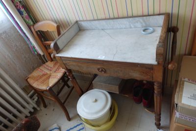 une petite table sur laquelle se trouve un bol, dans un coin de la pièce