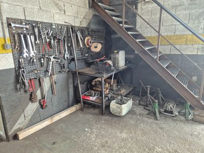 de nombreux outils accrochés au mur près d'un escalier