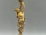 an antique brass candelab with four candles and a bird on top