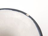 a close up of a white bowl with a black rim