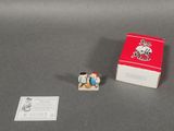 une petite figurine représentant un homme et une femme à côté d'une boîte d'allumettes