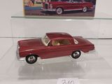 a red toy car on display in a glass case