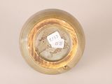 a gold vase with a white label on it