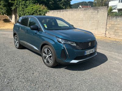 une voiture bleue garée sur le bord de la route, près d'un mur