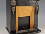 une cheminée ancienne noire et dorée, avec un manteau en bois