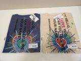two t - shirts on the table with tags on them