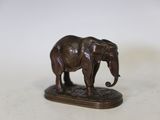 statue d'un éléphant debout sur un socle posé sur une surface blanche