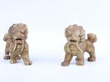 deux figurines représentant un chien et un lion sur un fond blanc
