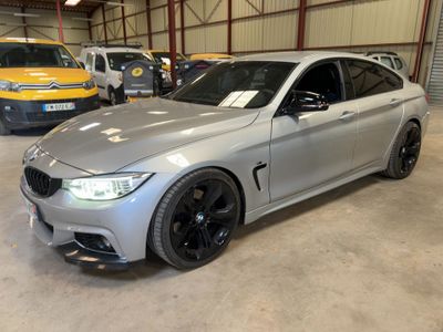 a silver bmw m4 is parked in a garage