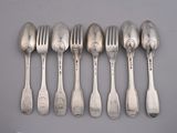 six cuillères et six fourchettes sont alignées sur une table