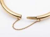 a close up of a gold choke with a chain attached to it