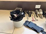 several pairs of scissors are sitting on a table next to a cup of scissors