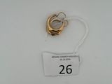 une bague en or et une étiquette blanche sur une surface blanche