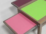 two tables with different colored tops sit side by side on a white surface