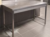 une table en acier inoxydable au milieu d'une pièce carrelée