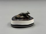 un gros plan sur une figurine représentant un chien allongé sur un livre