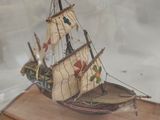 a small model of a boat in a glass case