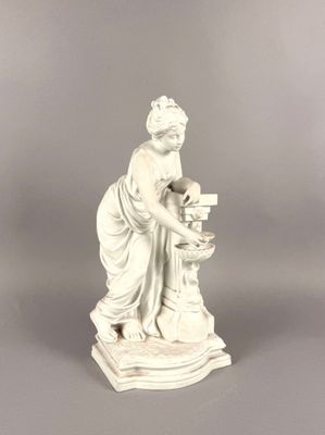 statue d'une femme tenant un panier de fleurs, posée sur un socle